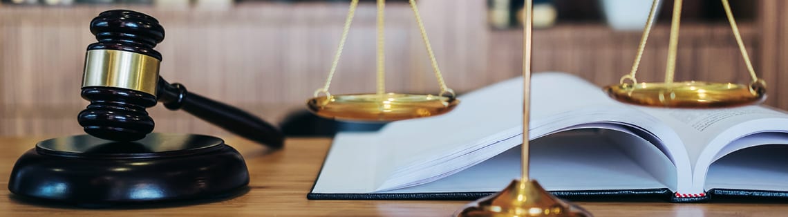 Current policies to watch for regarding solar in 2026 with a gavel and scales of justice.