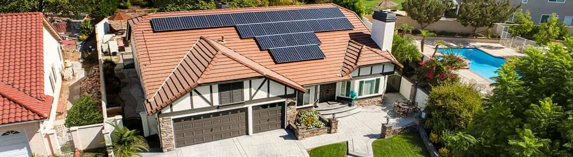 Aerial view of a house with solar panels, illustrating the question: How long will it take for solar panels to pay for themselves.