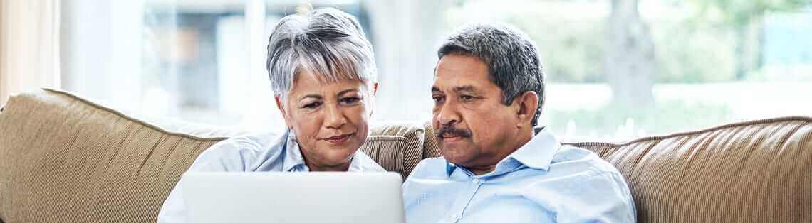 Couple researching 10 things you should know before installing solar panels on a laptop.