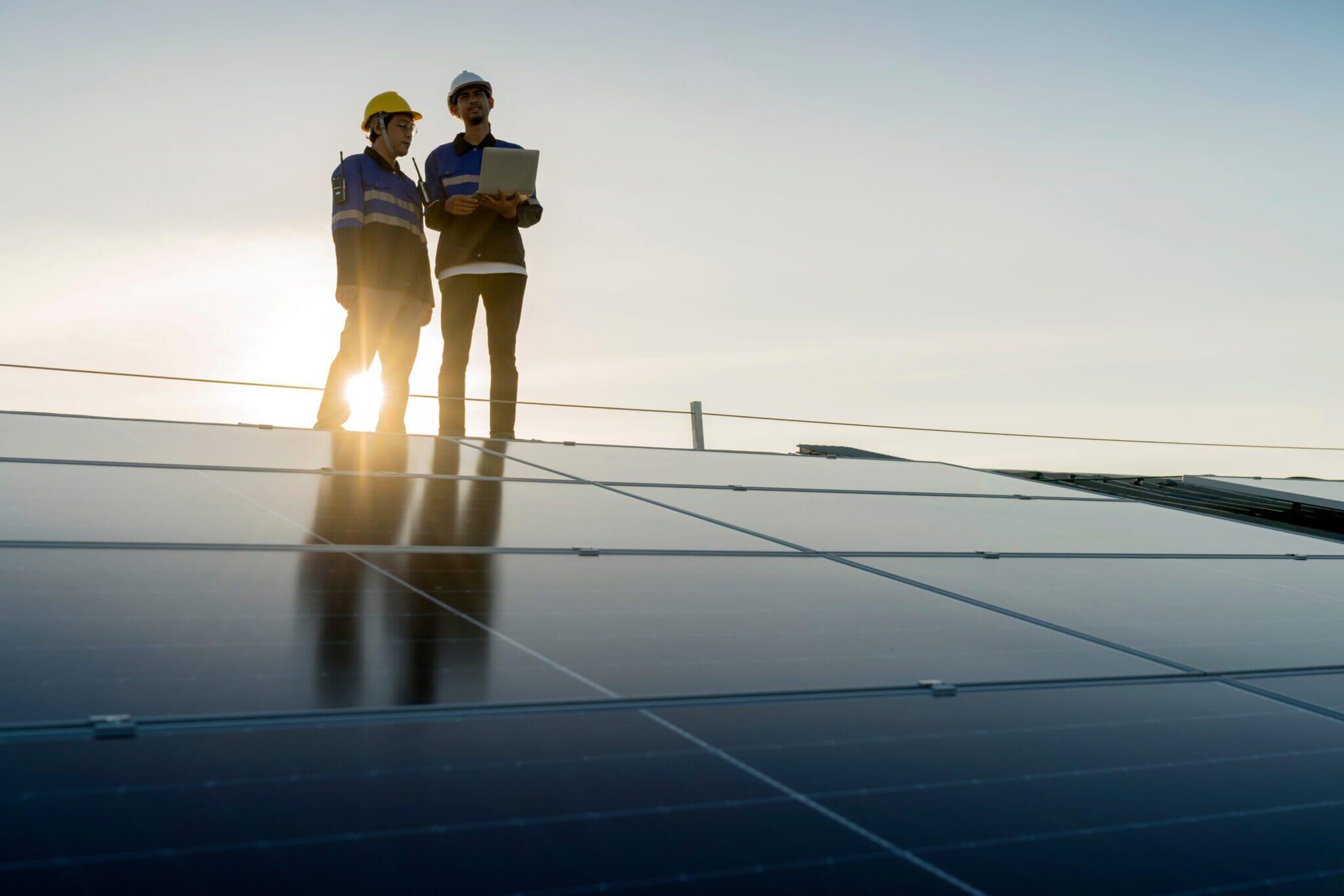 What Does it Take to Get Permission to Operate: Workers assessing solar panels on a rooftop.