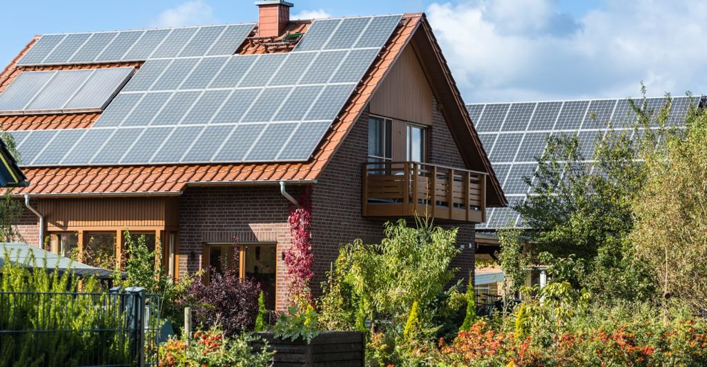 Solar power advantages and disadvantages showcased in a home with solar panels on the roof.