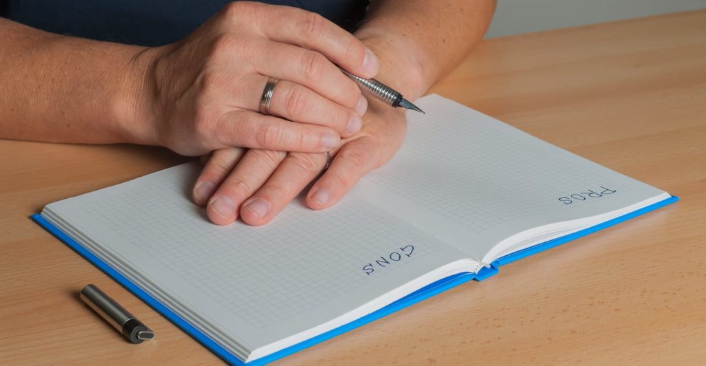 Person writing notes in a notebook, exploring the topic: What are the risks of solar panels.