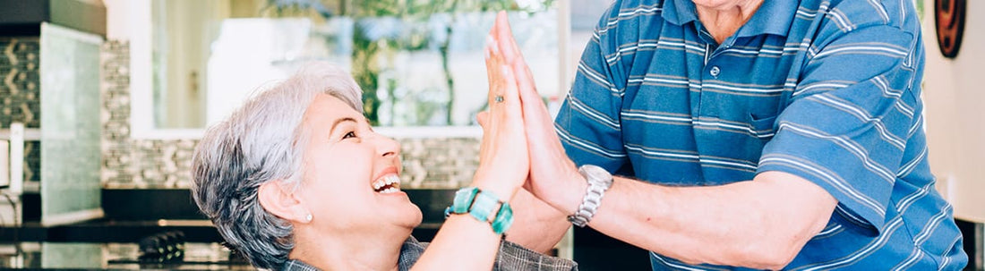Happy elderly couple sharing a joyful moment while learning how to fix and avoid high utility bills.